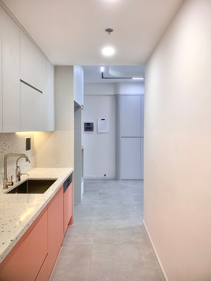 A sleek and modern minimalist kitchen with integrated cabinets and soft lighting.